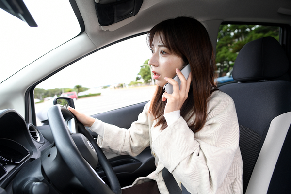 交通事故に遭い電話をする女性