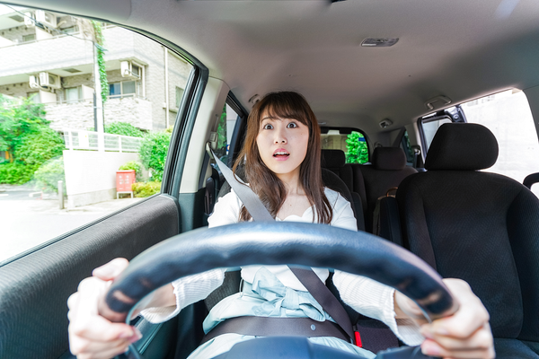 交通事故に巻き込まれ驚く女性運転手